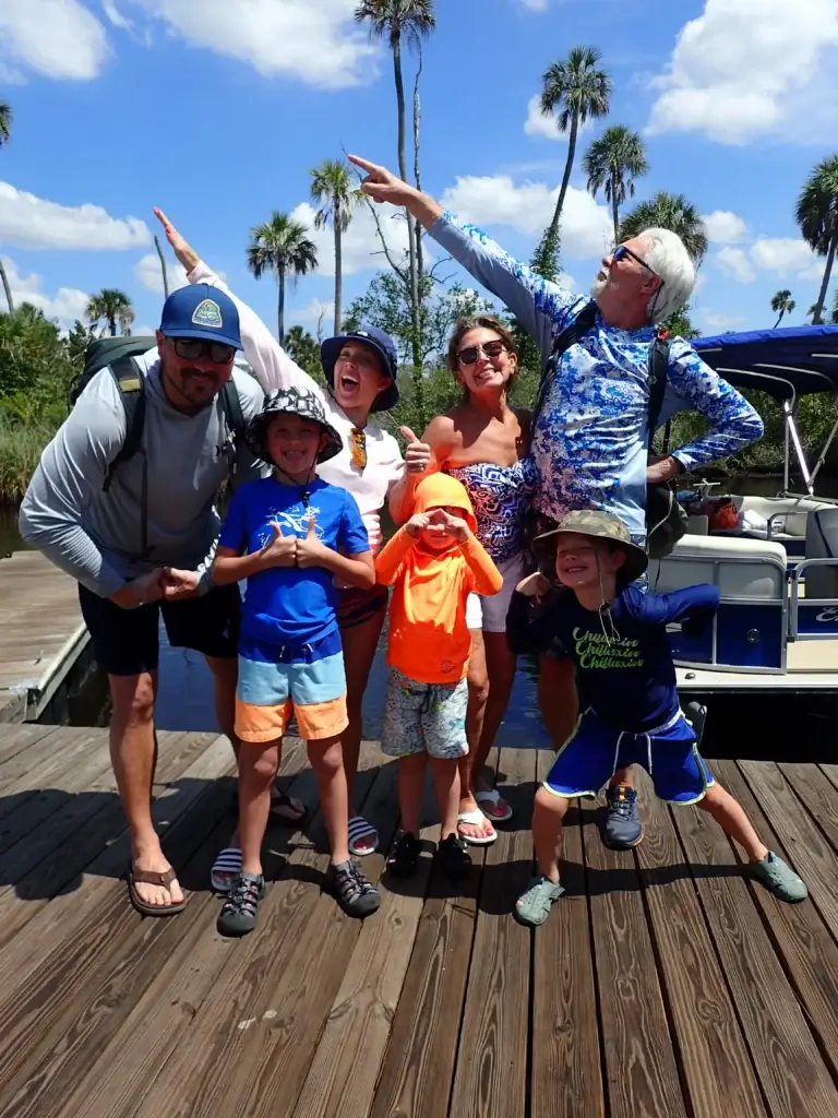 Three generations of a family striking a pose on the dock before their manatee tour