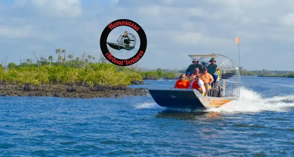 An airboat with guests skimming across the water past saw grass near Homosassa