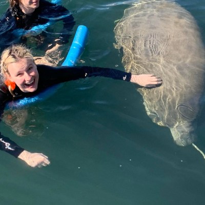 a young girl riding a wave on a surfboard in the water
